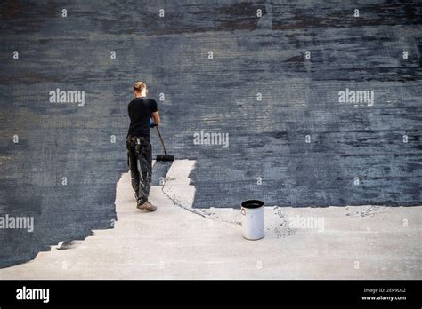 Construction site, application of a bituminous coating on a concrete ...