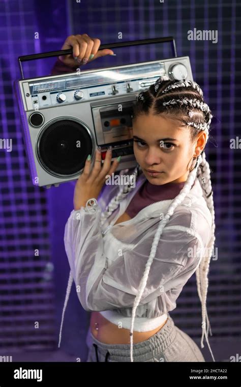 Portrait of a young girl with white braids with a boombox on her ...