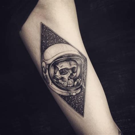 a skull in an astronaut's helmet tattoo on the arm