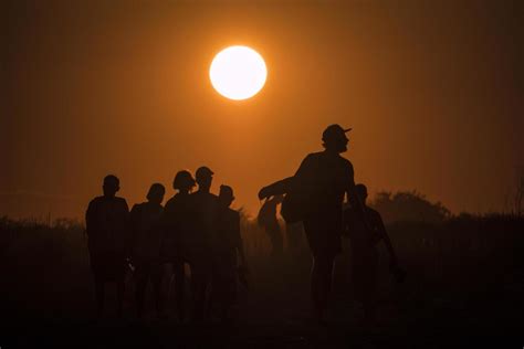 Silhouette of people walking on the beach at golden sunset 2029275 Stock Photo at Vecteezy