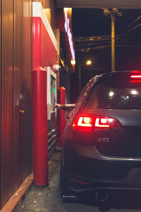Anonymous person buying products from drive thru in evening · Free Stock Photo
