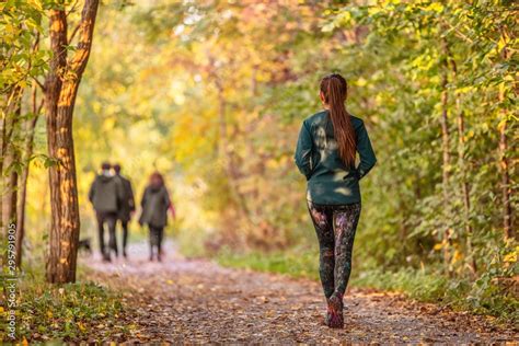 Woman walking in autumn forest nature path walk on trail woods ...