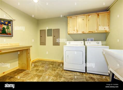Laundry roon with sink and folding desk and green walls Stock Photo - Alamy