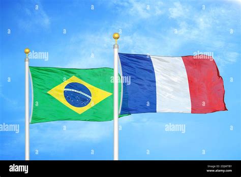 Brazil and France two flags on flagpoles and blue cloudy sky Stock ...