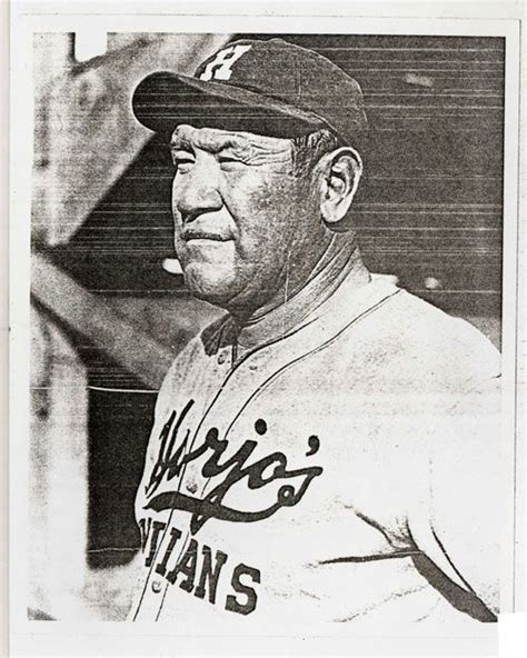 an old black and white photo of a man in a baseball uniform wearing a hat