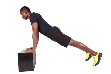 Fitness man doing incline push ups on black box