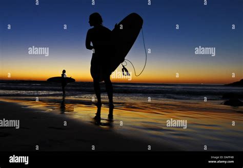 Surfers enjoy the sunset at Llandudno Beach in Cape Town, South Africa ...