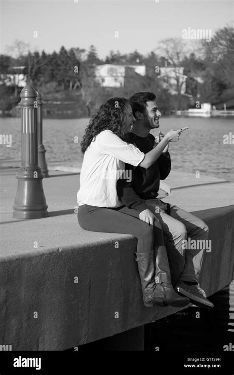 Couple sitting on a pier over looking a pond in black and white enjoying there day Stock Photo ...