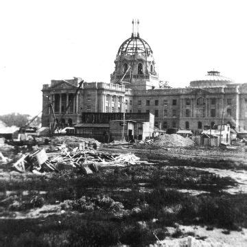 black and white photograph of an old building in the middle of town with debris everywhere