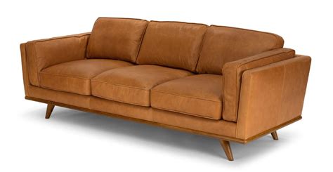An oak wooden trim and voluptuous leather cushions define this sofa with an updated mid-century ...