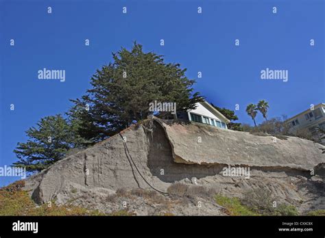 A house perched on the edge of an eroding cliff at Pismo Beach ...