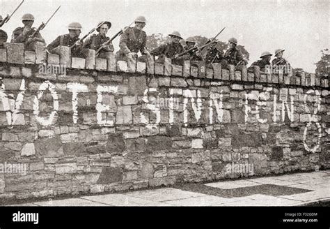 British troops guarding a wall which is plastered with a Sinn Fein advertisement during the ...