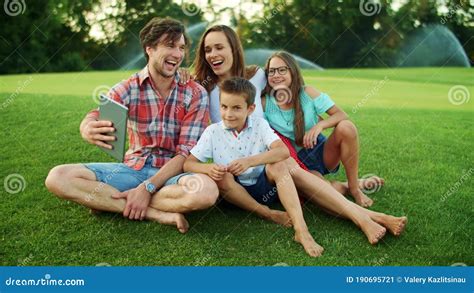 Family Laughing Together in Park. Family Having Video Chat on Pad in ...