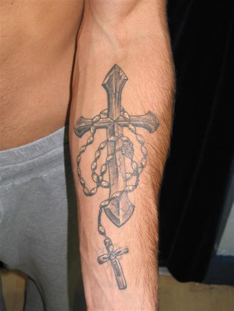 Religious gray-ink cross with beads tattoo on forearm - Tattooimages.biz