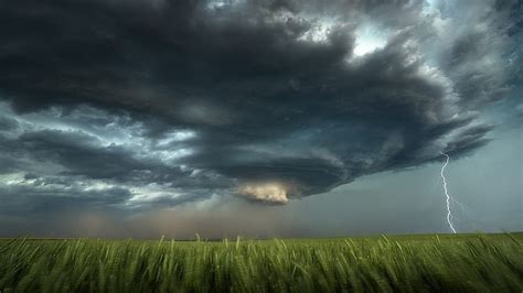 Campo verde bajo el cielo nublado con la naturaleza de tormenta ...