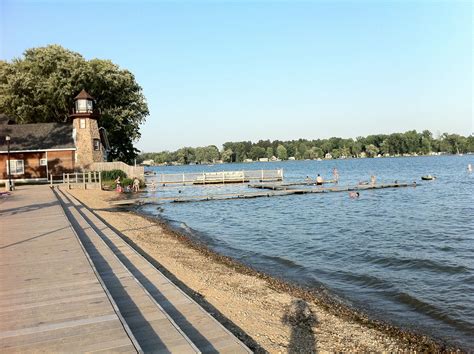 people are swimming in the water near a dock and some benches on the ...