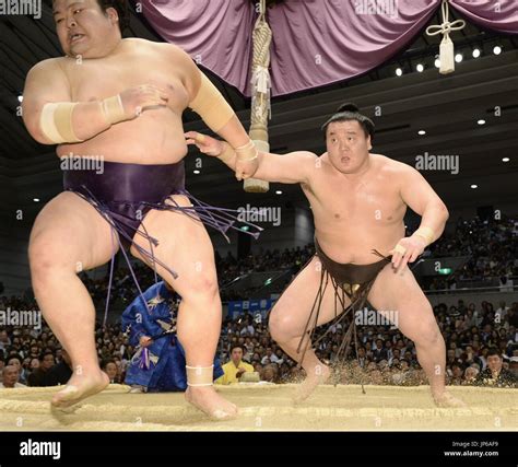 Mongolian grand champion Hakuho pushes rank-and-filer Takekaze out of the ring at the Spring ...