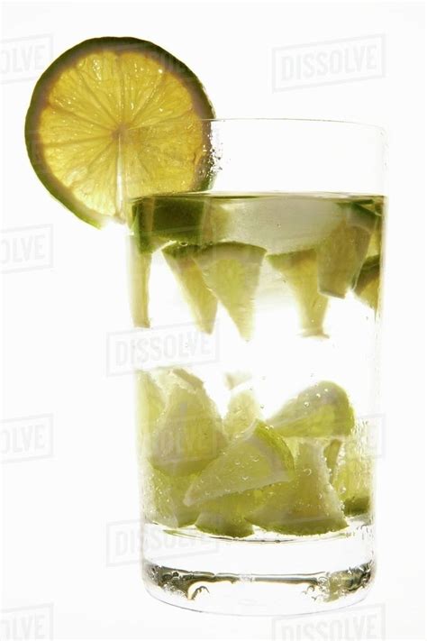 Mineral water with lime wedges, ice cubes & slice of lime - Stock Photo ...