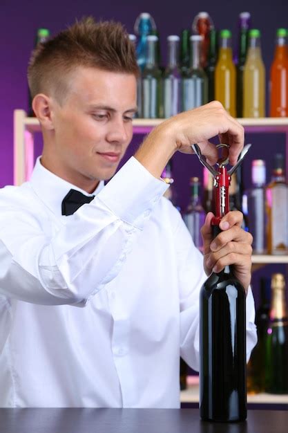 Premium Photo | Bartender opens bottle of wine