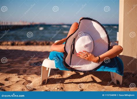 Girl Holding Hat while Lying on the Beach Stock Photo - Image of happy, attractive: 115734898