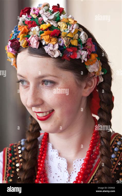 Poland, Cracow. Polish girl in traditional dress preparing to dance in ...