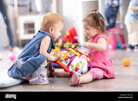 Conflict on the playground. Two kids fighting over a toy in kindergarten or nursery Stock Photo ...