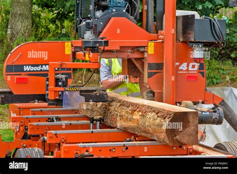 WOOD MIZER A TRANSPORTABLE SAWMILL IN ACTION SAWING A LOG OF WOOD Stock ...