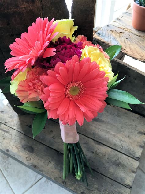 Prom bouquet featuring colorful coral gerbera daisies, yellow roses, coral and burgundy dianthus ...