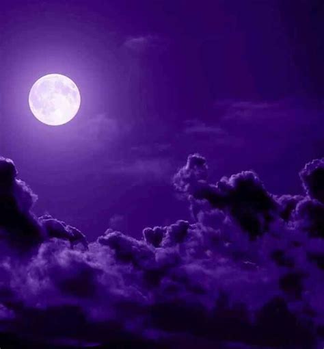 the full moon is shining brightly in the night sky with clouds and dark purple hues