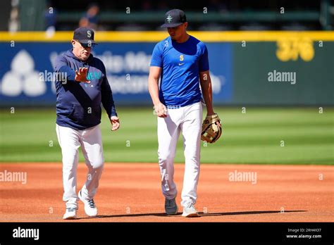 Seattle Mariners infield coach Perry Hill, left, talks with Josh Rojas ...