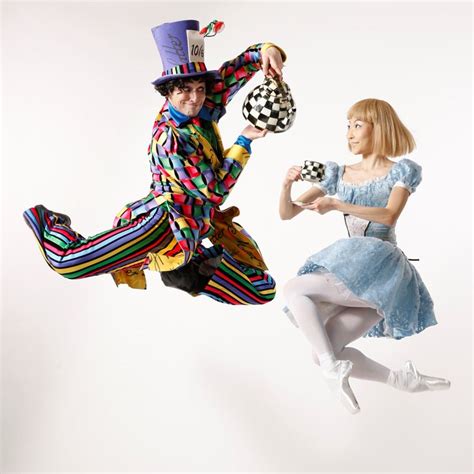 a man and woman dressed as clowns jumping in the air