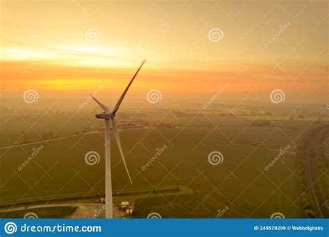 A wind turbine at sunset stock image. Image of field - 249579299