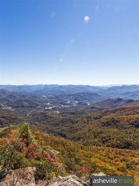 the view from top of a mountain looking down at valley and mountains in fall colors