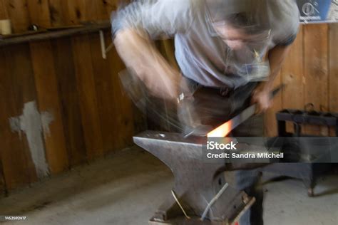 A Bladesmith At Work Forging A Knife Blade Out Of Metal Using A Hammer And Anvil Stock Photo ...