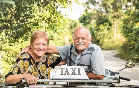 Happy retired senior couple taking travel photo at scooter taxi tour - Active elderly concept ...
