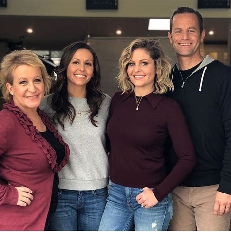 three women and one man are posing for the camera