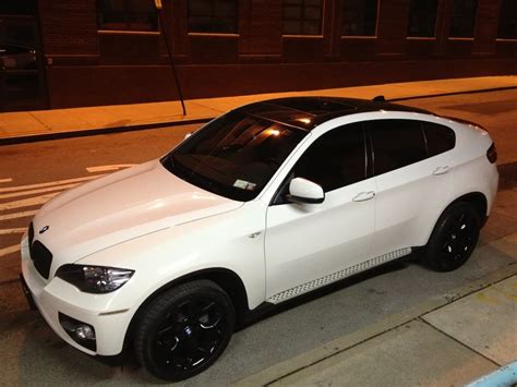 a white car is parked on the side of the street