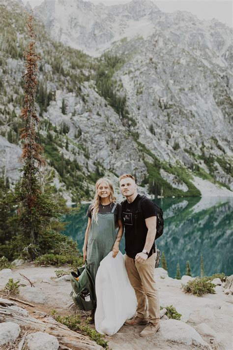 a man and woman standing on top of a mountain