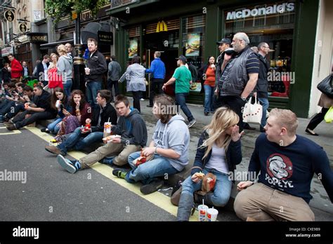 Young people eating McDonalds fast food on the street in London Stock Photo - Alamy