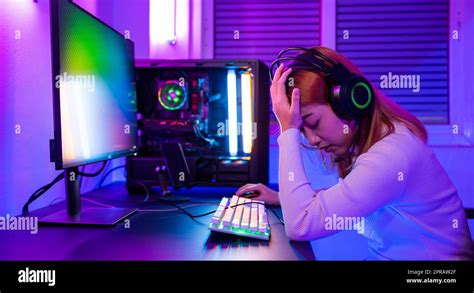 Angry Asian gamer wearing gaming headphones playing joystick console video game Stock Photo - Alamy