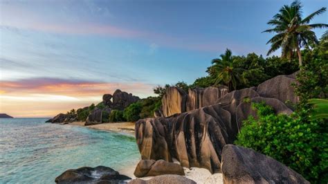 Sunset over rocks at beach Anse Source d'Argent, La Digue Island ...