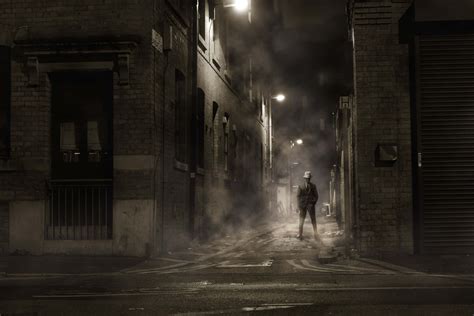 Download A Man Walking Down A Dark Alley | Wallpapers.com