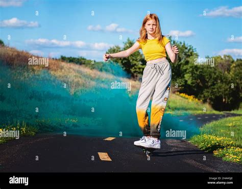 Tween girl ripsticking with blue smokebomb cloud Stock Photo - Alamy