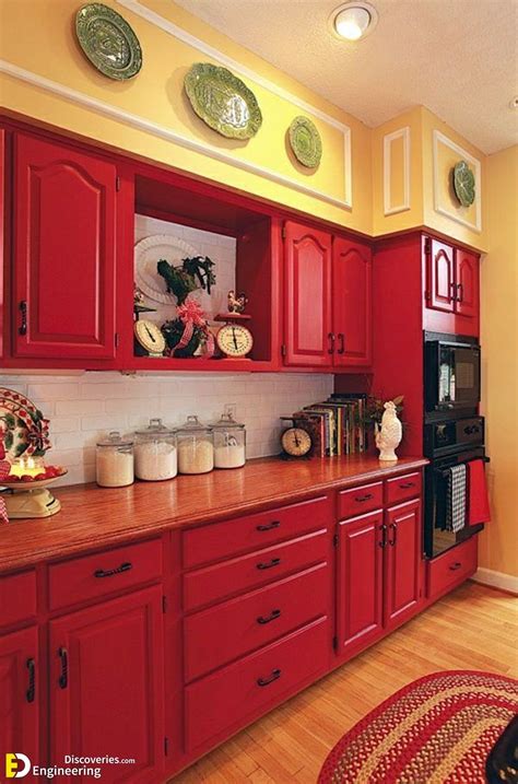 a kitchen with red cabinets and wooden floors