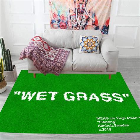 a green rug with the words wet grass on it in front of a white couch