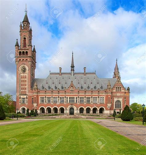 an old building with a clock tower in the middle of it's front lawn