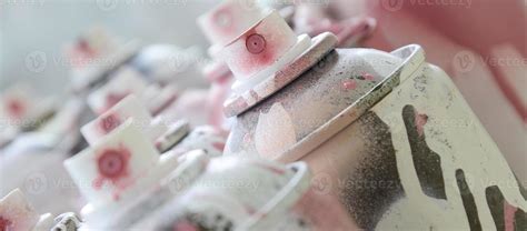 A lot of dirty and used aerosol cans of bright pink paint. Macro photograph with shallow depth ...