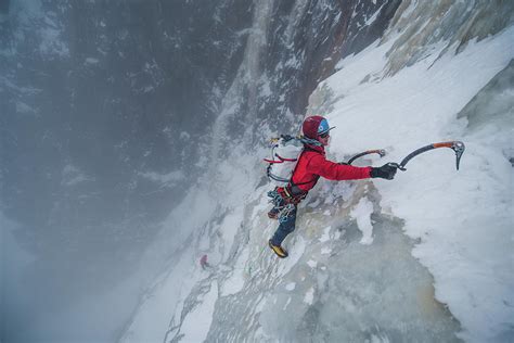 Ice Climber Climbing Steep Ice Wall With Rock Surrounding Him ...