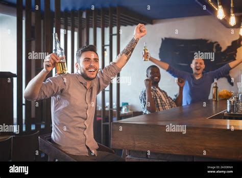 Happy football fans celebrating victory, watching match at bar Stock Photo - Alamy