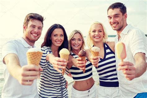 Smiling friends eating ice cream on beach Stock Photo by ©Syda ...